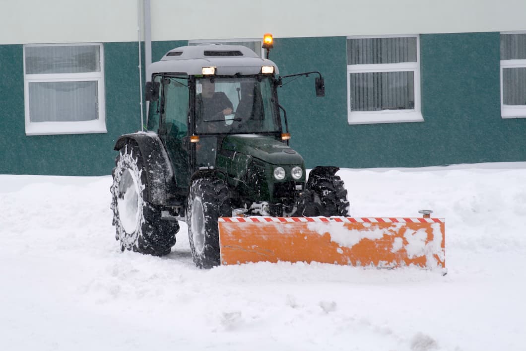 Small Tractor Plowing Snow